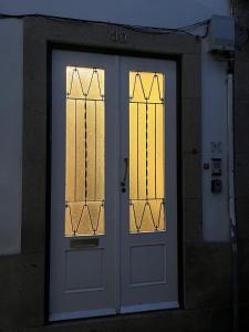 a white door with two windows on a building at Fortaleza Faro in Valença
