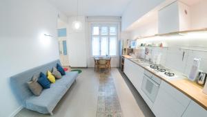 a living room with a blue couch in a kitchen at NewSunny Apartment at the BudaCastle in Budapest