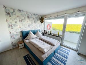 a bedroom with a bed and a large window at Haus Nautic Döse Wohnung 123 in Cuxhaven