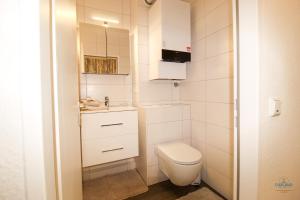 a small bathroom with a toilet and a sink at Haus Nautic Döse Wohnung 123 in Cuxhaven +12 photos