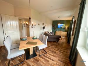 a dining room with a table and chairs and a couch at Strandbude 2 Döse in Cuxhaven