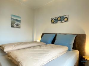 a bedroom with two beds with blue pillows at Strandbude 2 Döse in Cuxhaven +13 photos