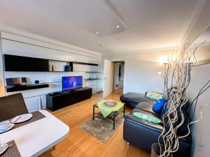 a living room with a couch and a tv at Haus Nautic Döse Wohnung 214 in Cuxhaven