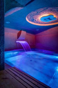 a large hot tub in a room with blue lights at SADU hotel in Almaty
