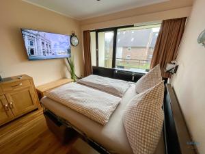 a bedroom with a bed and a large window at Whg. 121 Haus Jan am Strand in Cuxhaven