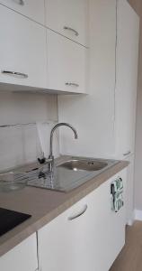 a white kitchen with a sink and white cabinets at Loano Casa Archè villa indipendente con giardino in Loano