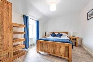 a bedroom with a bed with blue sheets and a staircase at Finest Retreats - Blaen Ddol in Betws-y-coed