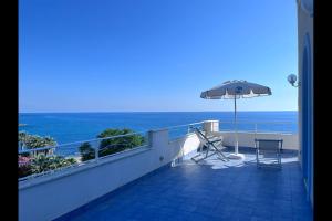 a balcony with an umbrella and a table and chairs at Hotel Ferretti in Diamante