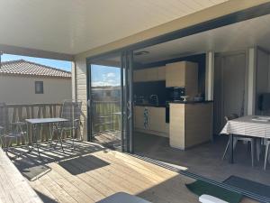 une cuisine et un balcon avec une table et des chaises dans l'établissement Cottage 79 Landes nature, à Saubrigues