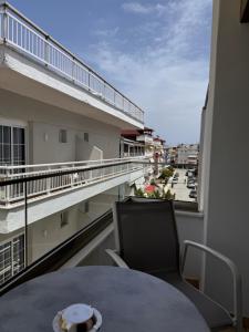 a balcony with a table and a view of a street at Villa Hara Suites in Paralia Katerinis
