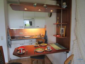 a small kitchen with a table with dishes on it at Ferienwohnung 223 Haus Nautic in Cuxhaven