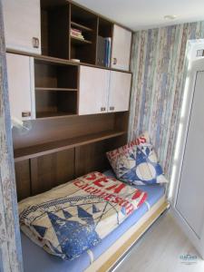 a bed in a small room with a cabinet and pillows at Ferienwohnung 223 Haus Nautic in Cuxhaven +12 photos