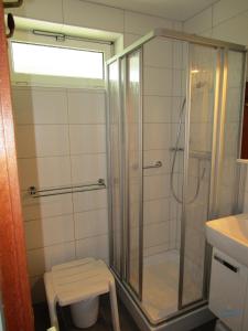 a bathroom with a shower and a stool in it at Ferienwohnung 223 Haus Nautic in Cuxhaven