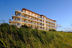 un edificio in cima a una collina con erba alta di Haus Blue Ocean Wohnung 8 a Cuxhaven