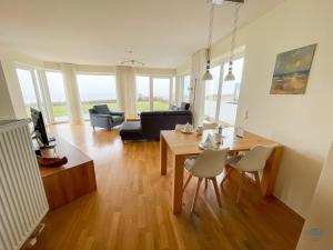 un soggiorno con tavolo e sedie di Haus Blue Ocean Wohnung 8 a Cuxhaven