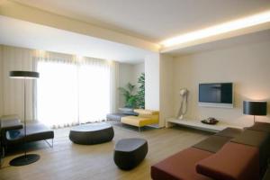 a living room filled with furniture and a flat screen tv at Art Hotel Udine in Udine