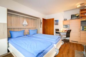 クックスハーフェンにあるStrand und zentrumsnahe Ferienwohnung für bis zu 2 Personen in Döseのベッドルーム1室(大型ベッド1台、青いシーツ付)