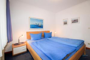 a bedroom with a large bed with blue sheets at Strand und zentrumsnahe Ferienwohnung für bis zu 4 Personen in Döse in Cuxhaven