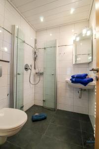 a bathroom with a shower and a sink and a toilet at Strand und zentrumsnahe Ferienwohnung für bis zu 4 Personen in Döse in Cuxhaven +14 photos