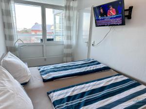 Un dormitorio con dos camas y un televisor de pantalla plana. en Urlaub mit spektakulärer Aussicht auf das Wattenmeer, en Cuxhaven 12 fotos más