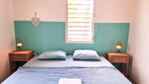 a bedroom with a bed with two nightstands and a window at 12 Casa Hermanito in Kralendijk +8 photos