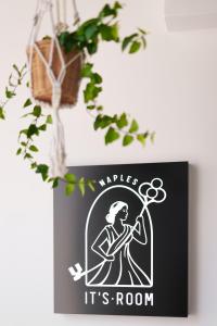a sign with a woman holding a tennis racket at It’s Room in Naples