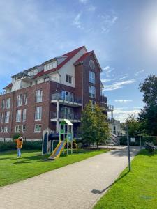ein Gebäude mit einem Spielplatz vor einem Gebäude in der Unterkunft Residenz Hohe Lith Wohnung 04 01 in Cuxhaven