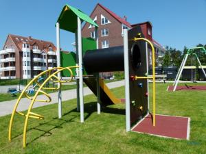 ein Spielplatz mit Rutsche in einem Park in der Unterkunft Residenz Hohe Lith Wohnung 04 01 in Cuxhaven