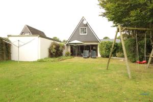 a house with a yard with a swing at Ferienhaus Christian Brütt Weg 23 in Cuxhaven +12 photos
