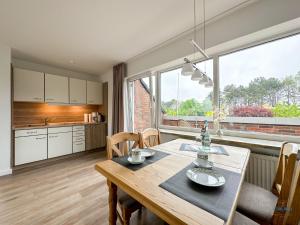 a kitchen and dining room with a wooden table at Refugium Storchenwiese Wohnung 2 in Cuxhaven