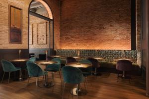 a restaurant with tables and chairs and a brick wall at Hotel Boutique La Pau in Barcelona