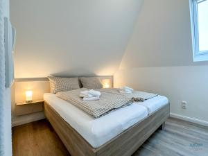 a bedroom with a bed with two towels on it at Refugium Storchenwiese Wohnung 2 in Cuxhaven