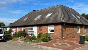 a red brick house with a black roof at Refugium Storchenwiese Wohnung 2 in Cuxhaven