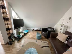 uma sala de estar com um sofá e uma televisão em Residenz Hohe Lith Wohnung 34 Haus 3 em Cuxhaven
