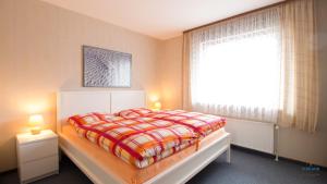 un dormitorio con una cama y una ventana en Haus Kerstin Duhnen Wohnung 8, en Cuxhaven