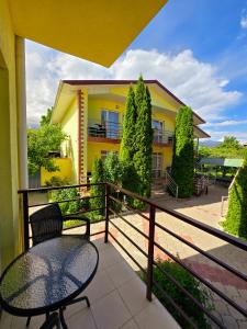 a balcony with a table and chairs and a building at Guest House Moryachka in Bosteri