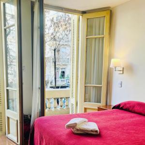 a bedroom with a red bed and a window at Hotel Alcazar in Buenos Aires +57 photos