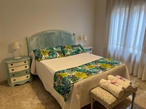 a bedroom with a bed with a green headboard and a chair at Quererte in Teruel