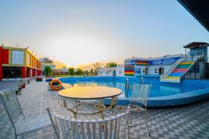 a table and chairs next to a swimming pool at Ramas Resort in Nawai