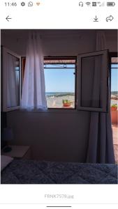een slaapkamer met een raam met uitzicht op het strand bij Casa Gaia in Golfo Aranci