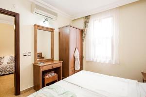 a bedroom with a bed and a mirror and a window at Amber-Rose Apart Hotel in Alanya +51 photos