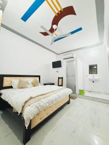 a bedroom with a bed with a ceiling fan at Hotel Krishna cottage in Ayodhya