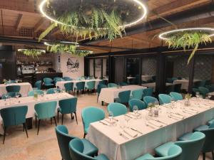 a dining room with white tables and blue chairs at A Casa Da Canle in Braño