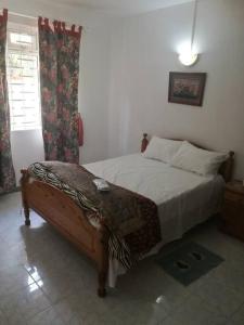 弗利康弗拉克Ideally Located, Fully Furnished, Air Cond Apartment In Flic En Flac !ONLY 5 mins walk to the beach的一间卧室，里面有一张床和一扇窗户。