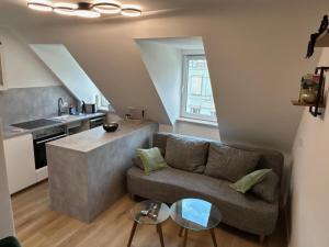 a living room with a couch and a kitchen at Moderne Wohnung in zentraler Lage, Schallschutzfenster, Self-check-in, Netflix, Disney Plus in Hannover