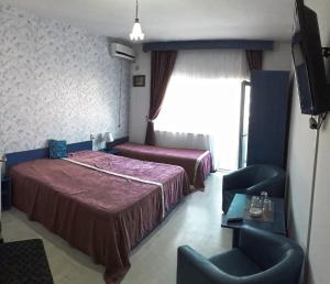 a hotel room with two beds and a flat screen tv at Eforie Brio in Eforie Nord