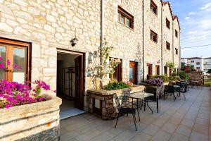a patio with tables and chairs next to a building at Stone Villas Dukes in Paralion astros