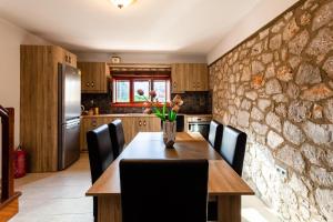 a kitchen with a wooden table and a stone wall at Stone Villas Dukes in Paralion astros