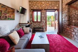 a living room with a couch and a table at Stone Villas Dukes in Paralion astros