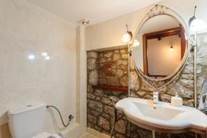 a bathroom with a sink and a mirror at Stone Villas Dukes in Paralion astros +37 photos